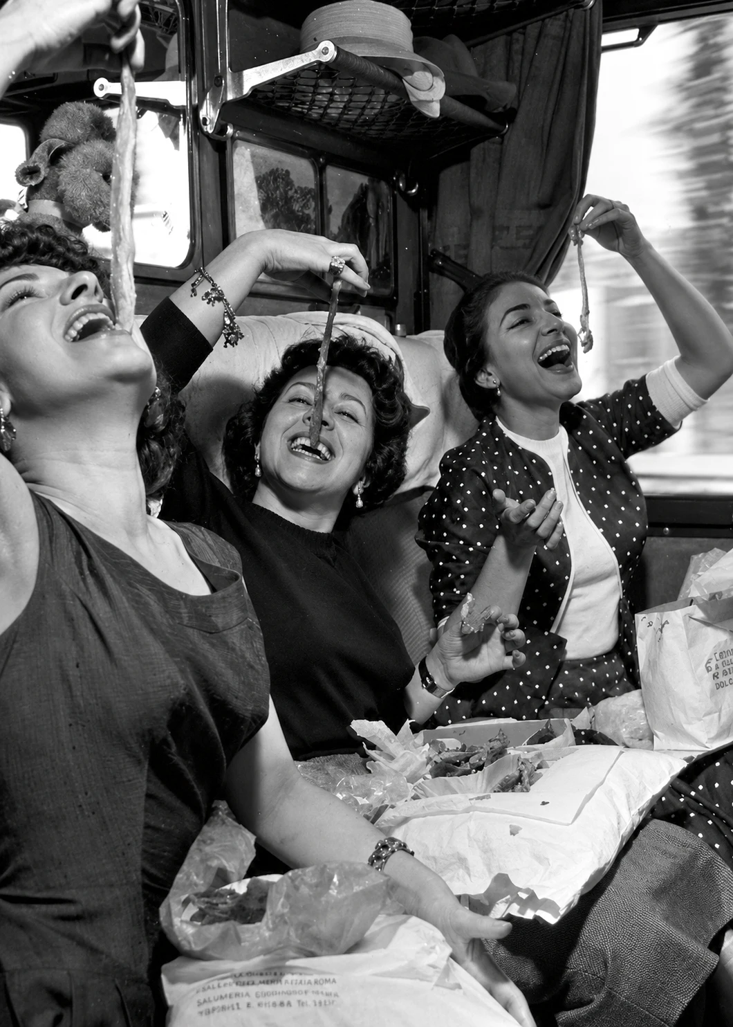 Scène de cinéma italien : trois femmes rient à table